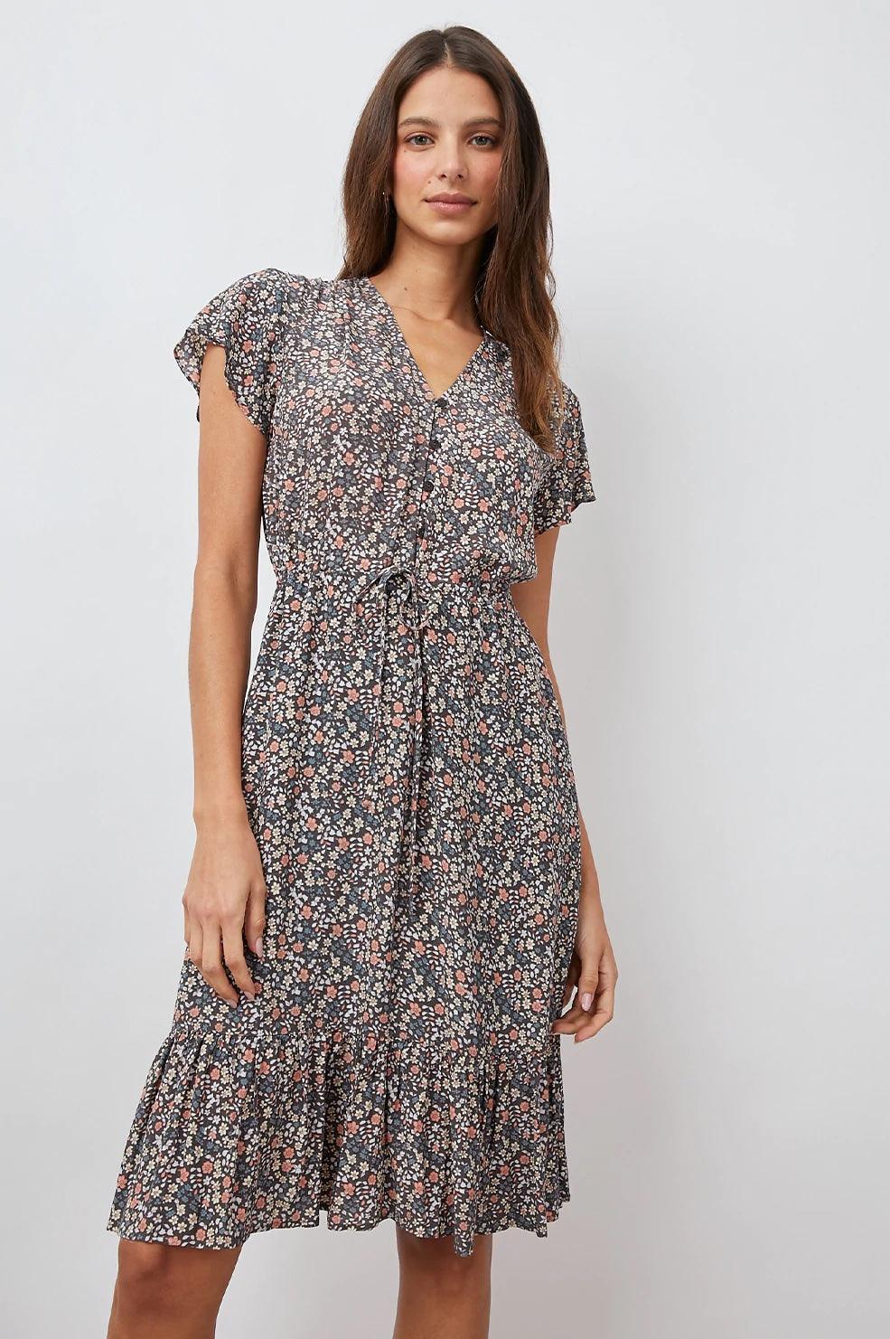 Kvinne med sort sommerkjole med vintage blomstermønster og korte ermer