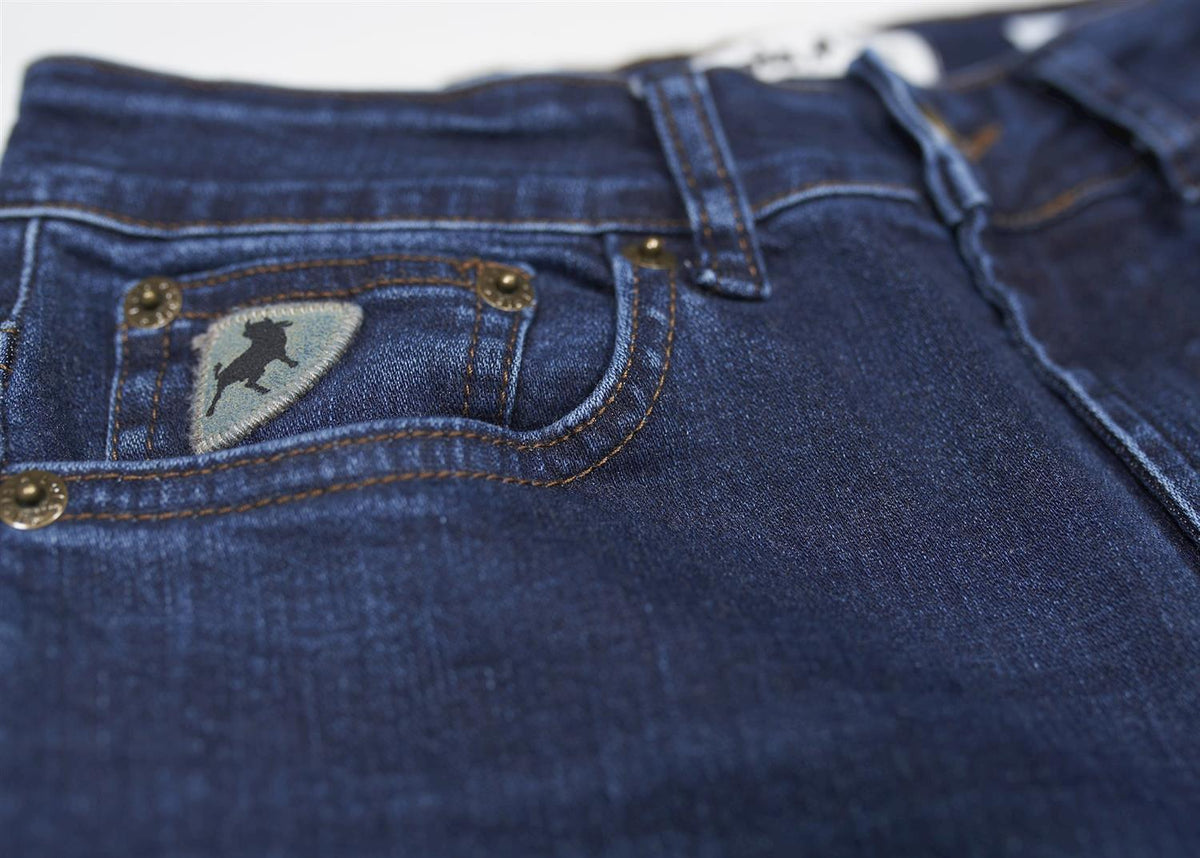 Nærbilde av blå jeans med detaljert lomme og brodert logo for dameklær.