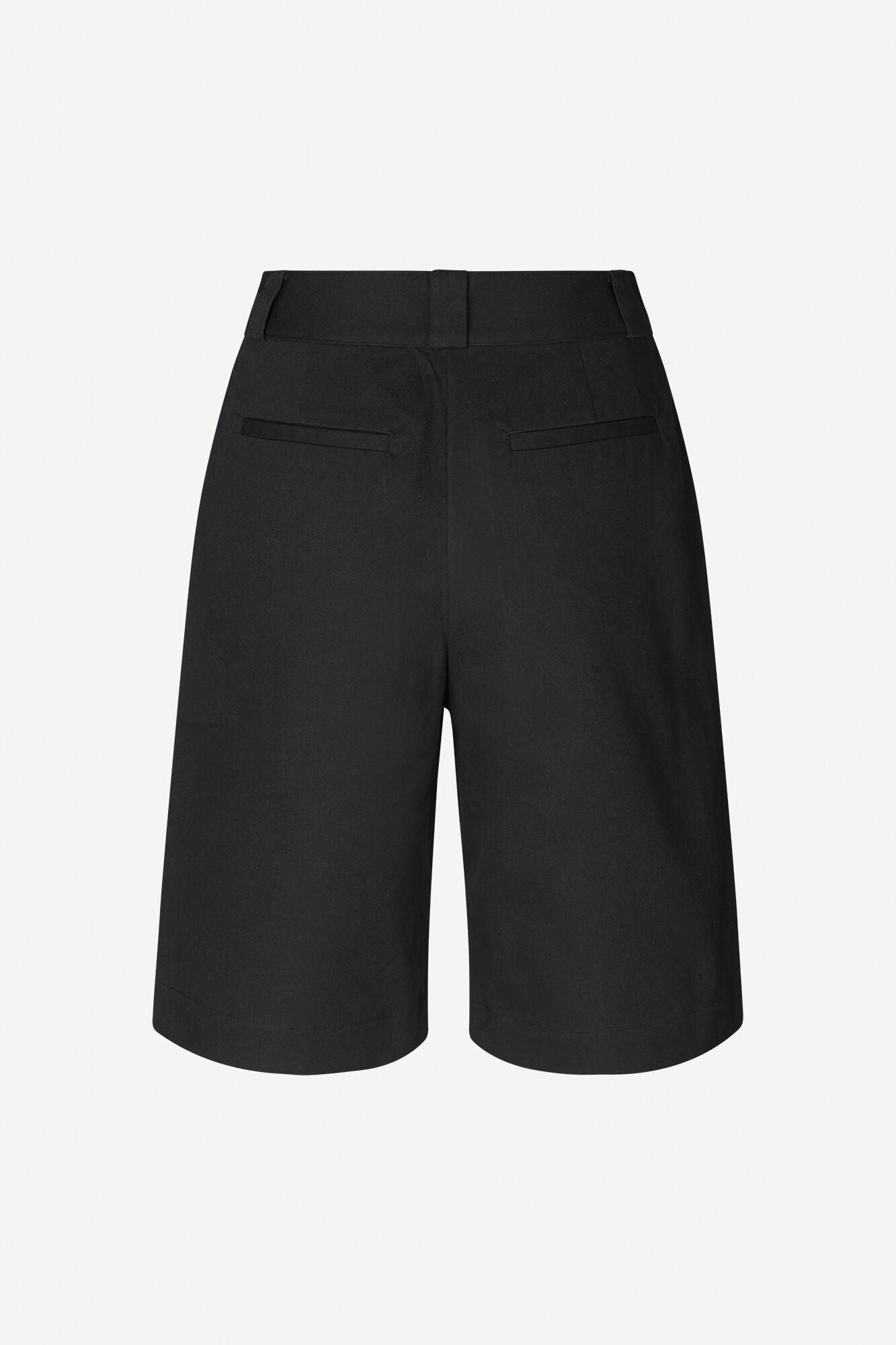 Bakside av klassiske svarte dame-shorts med passpolerte lommer og beltehemper.